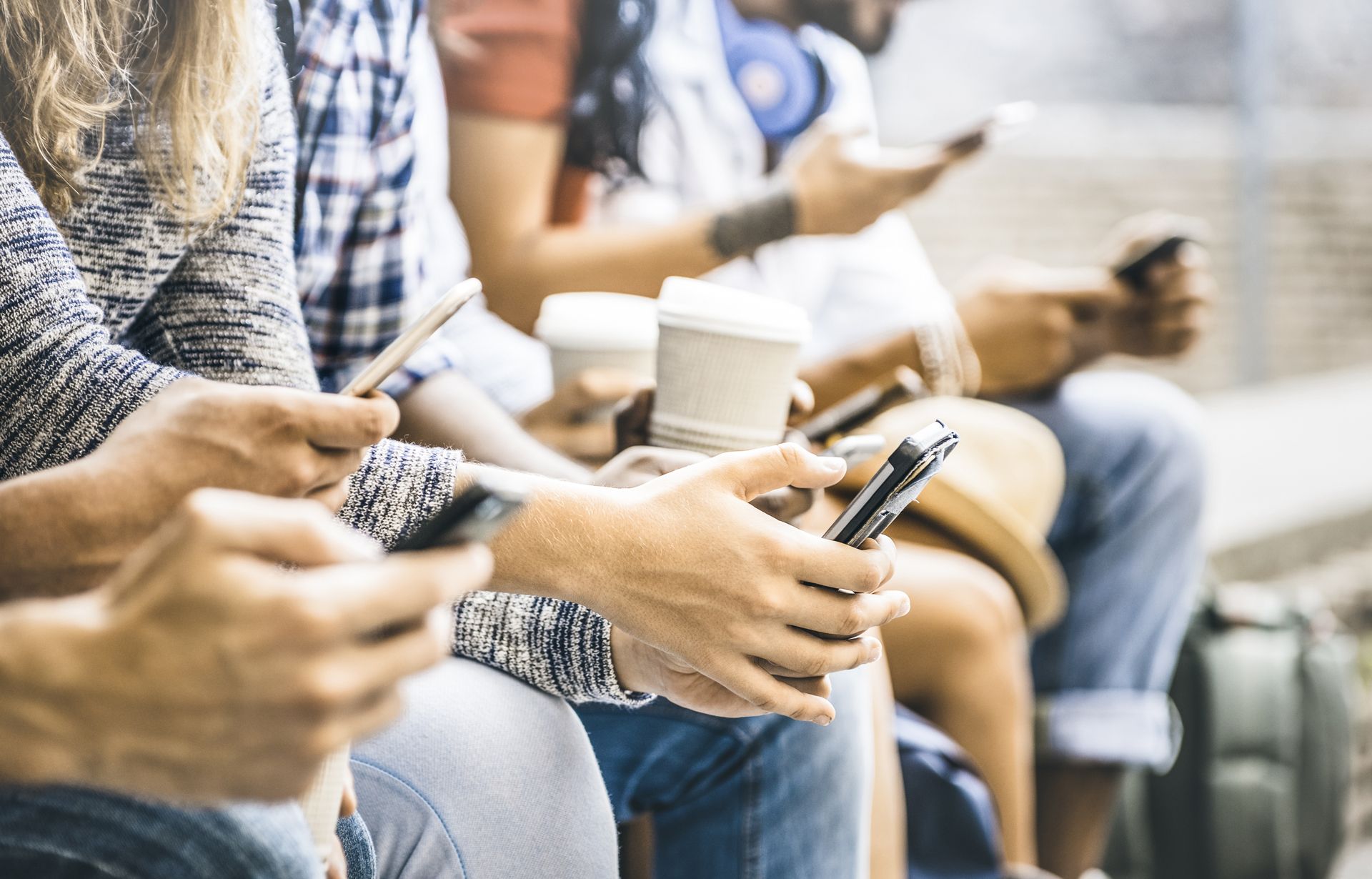 A row of people all using their cell phones