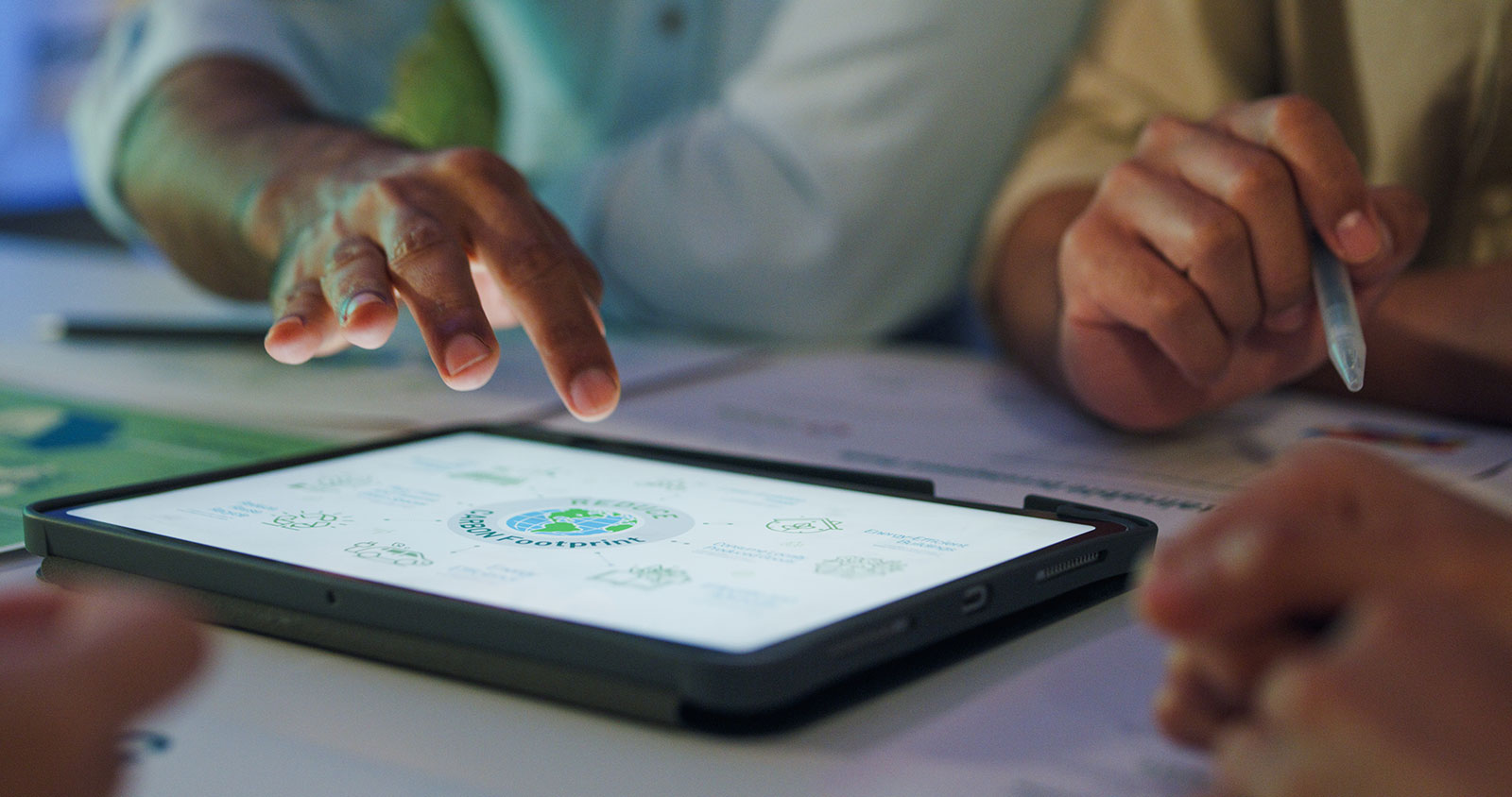 People reviewing a sustainability plan on a tablet