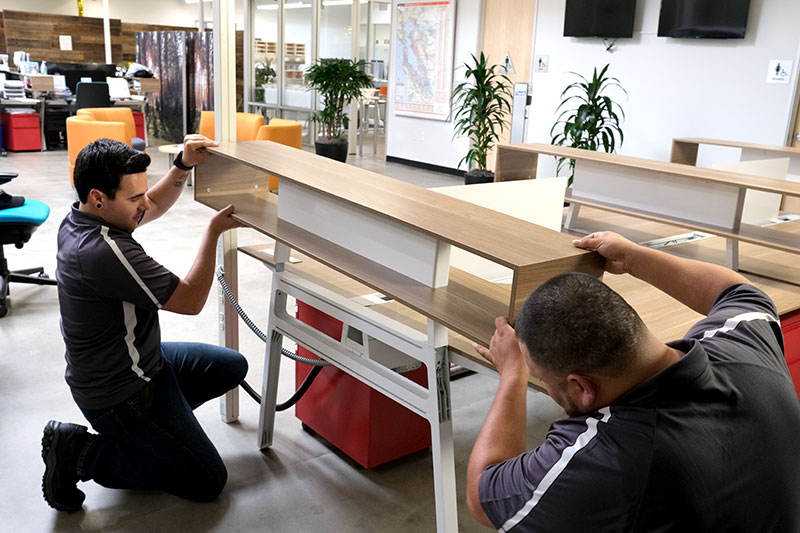 Commercial movers putting together office furniture