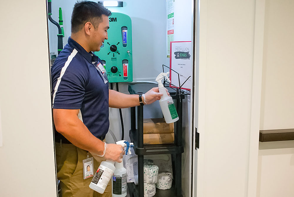 Night janitor restocking supplies in a janitorial closet