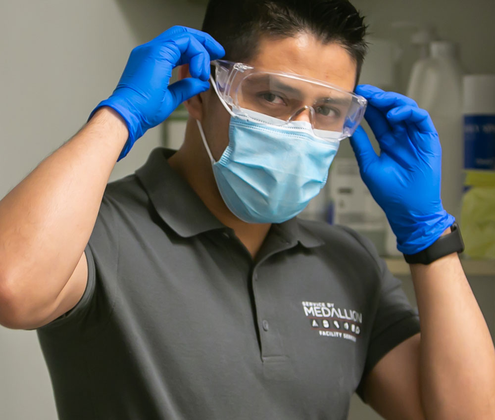 janitor putting on personal protective equipment