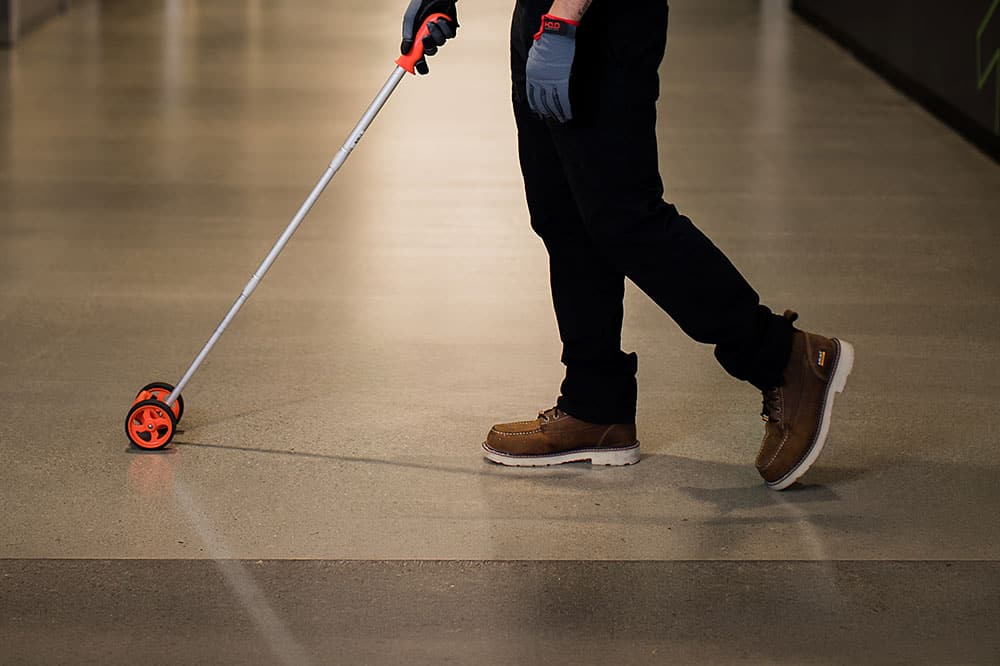 project manager measuring the hallways of a commerical office with a measuring wheel