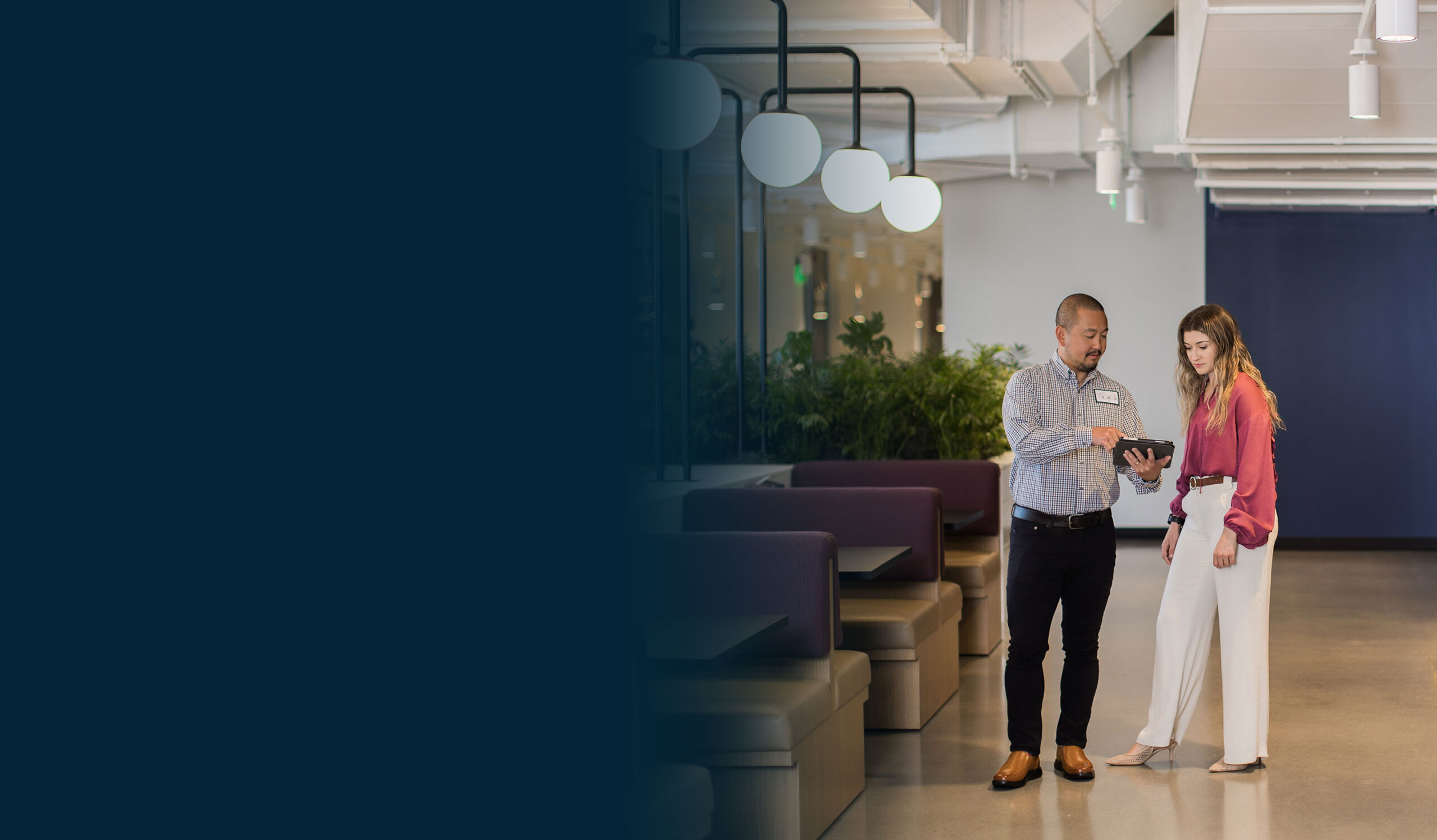 Facility services professional reviewing information with a client in a modern workplace environment
