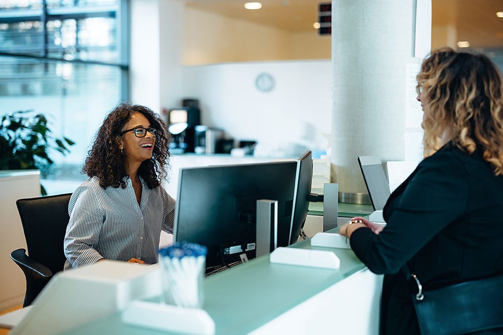 Receptionist helping a person at a reception desk