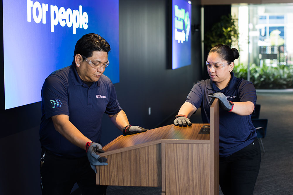 corporate event staff moving a podium in preperation for an event
