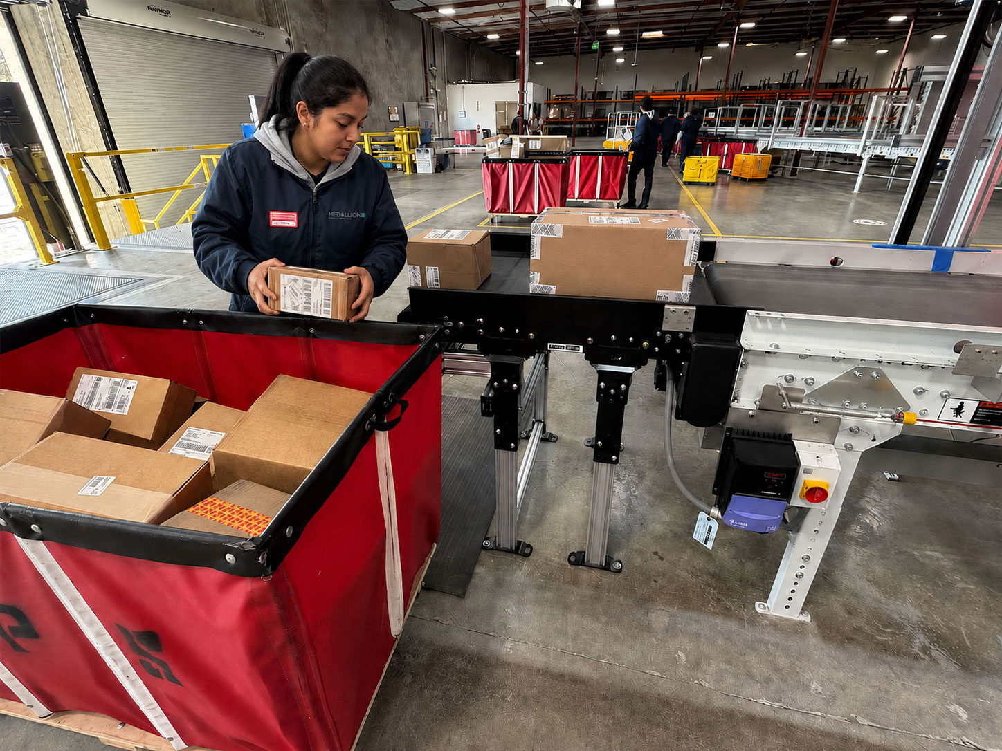 Mailroom staff sorting packages in a university warehouse